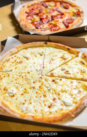 Delicious Italian pizza delivered for lunch in cardboard boxes. Two tasty pizzas cooked on oven for dinner Stock Photo
