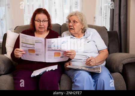 Older female couple reading a utility bill. Manchester. United Kingdom. Stock Photo