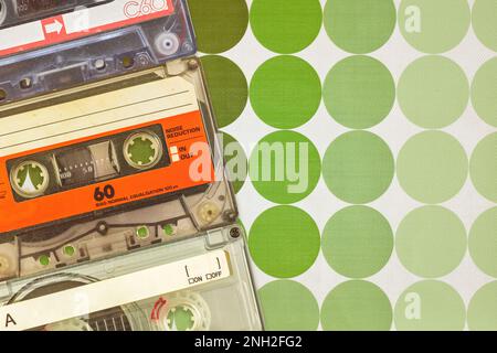 Three colorful vintage audio compact cassettes in front of seventies retro wallpaper Stock Photo