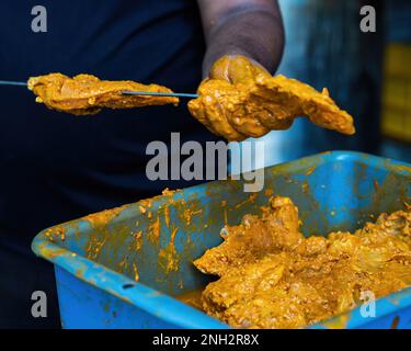 Prepping the chicken skew Kebab barbeque with marinated spices. Traditional Indian and Pakistan dish. Stock Photo