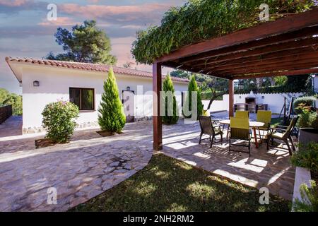 Family home on its own land, pine trees, hedges, tiled walkways. Stock Photo