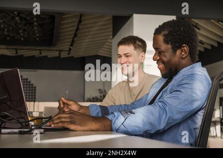 Two programmers working in the office of a software development company. Coding technologies, site design. Successful diverse Teamwork. Cyberspace Stock Photo