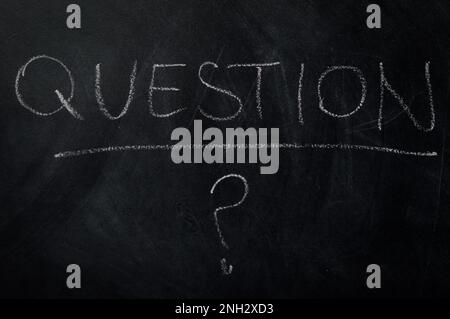 Do you have any questions? the word question handwritten with chalk on a blackboard with question mark - concept for existential or practical question Stock Photo