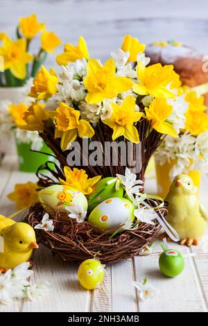 Easter table decoration with fresh daffodils,chick and eggs Stock Photo