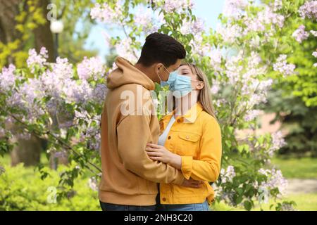 Couple in medical masks trying to kiss outdoors Stock Photo - Alamy
