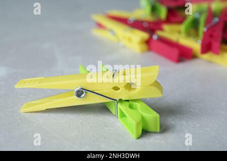 Colorful plastic clothespins on grey table, closeup Stock Photo