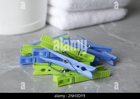 Colorful plastic clothespins on grey table, closeup Stock Photo