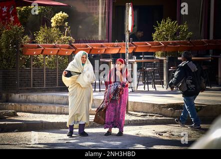 Sousse, Tunesia, January 30, 2023: Two wrinkled-faced elderly Berber women in traditional dress on a sidewalk Stock Photo