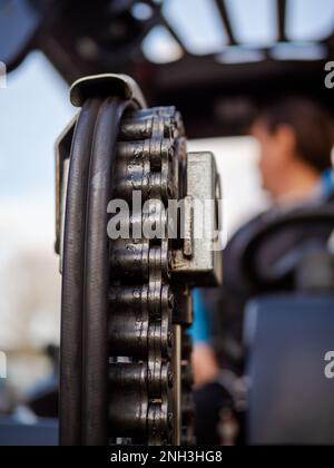 closeup of lifting chain on a hydraulic operated fork lift truck driven by a woman worker Stock Photo