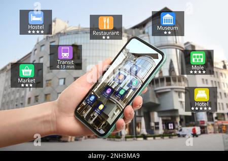 Tourist using online guide application on smartphone for navigation in city, closeup. Augmented reality information technology Stock Photo