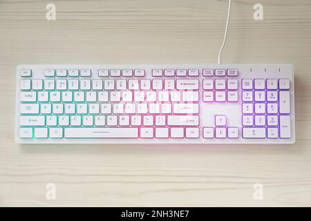 Modern RGB keyboard on white wooden table, top view Stock Photo