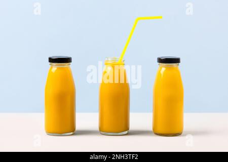 Three pineapple smoothies for healthy eating in glass bottles with a straw. Healthy, detox and dietary nutrition concept. Stock Photo