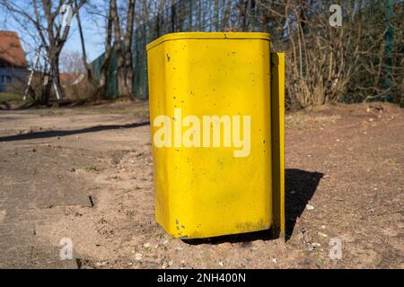 Square yellow trash can in the park Stock Photo