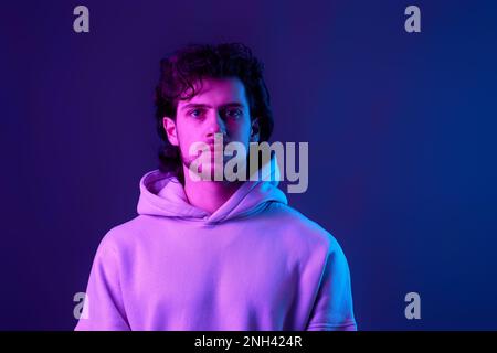 handsome bearded man in sweatshirt on blue background. Stock Photo