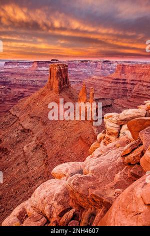 Colorful winter sunrise clouds over the Crow's Head Spires and Bird's View Butte from Marlboro Point near Moab, Utah.  In the distance is the Island i Stock Photo