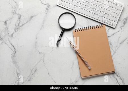 Notebook, pen, magnifier and keyboard on light background. World Poetry Day celebration Stock Photo