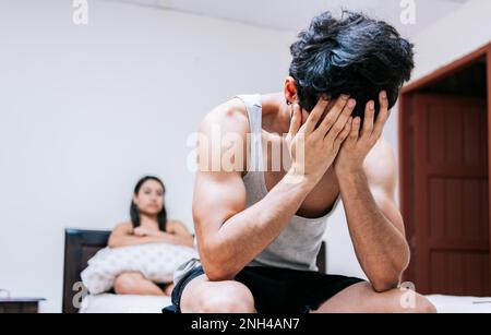 Worried man in bed with erectile dysfunction. Concept of crisis and couple problems in bed, Worried man sitting on the side of the bed and angry Stock Photo
