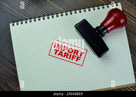 Concept of Red Handle Rubber Stamper and Import Tariff text isolated on on Wooden Table. Stock Photo