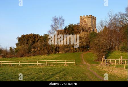 Church in the English countryside with field and trees. Late afternoon just before sunset. St John's Church, West Wickham, Kent, UK. Stock Photo