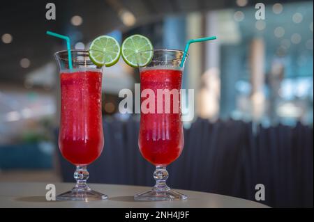 Cocktail with lime. Two glasses of red cocktails on table in the restaurant. Stock Photo