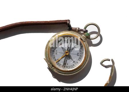 vintage compass with leather strap isolated on white background, harsh shadow Stock Photo