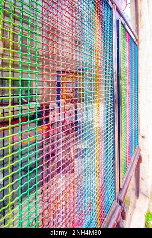 abstract metal grill with rainbow colours painted in Lisbon Portugal Stock Photo