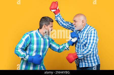 aggressive two generation men has disagreement isolated on yellow. generation men Stock Photo