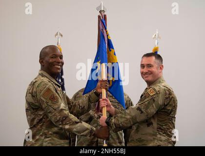Maj. David Ratté, right, assumes command of the 436th Security Forces Squadron after receiving the guidon from Col. Phelemon Williams, left, 436th Mission Support Group commander, during a change of command ceremony held at The Landings on Dover Air Force Base, Delaware, June 21, 2022. Ratté was previously the 768th Expeditionary Air Base Squadron defense force commander. Stock Photo