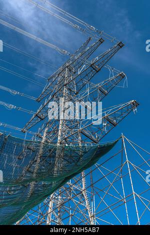 A newly installed high-voltage pylon with some cables connected Stock Photo