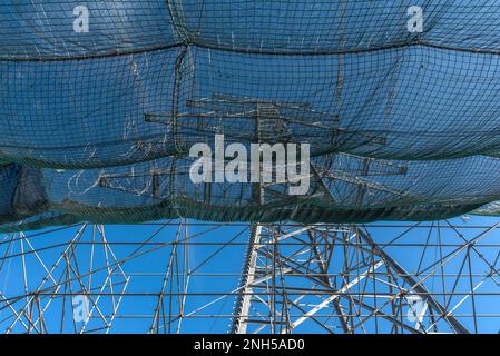 A newly installed high-voltage pylon with some cables connected Stock Photo