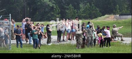 Soldiers assigned to the 'Mustang Squadron,' 6th Squadron, 8th Cavalry Regiment, 2nd Armored Brigade Combat Team, 3rd Infantry Division, and their families watch the newly modernized M1A2 SEPv3 Abrams tank fire during the squadron's family day on Fort Stewart, Georgia, July 17, 2022. Family days give the unit and the garrison the opportunity to form and nurture relationships with Soldiers' families and the local community, building lasting connections and bonds that demonstrate the Army's commitment to family and the community. Stock Photo