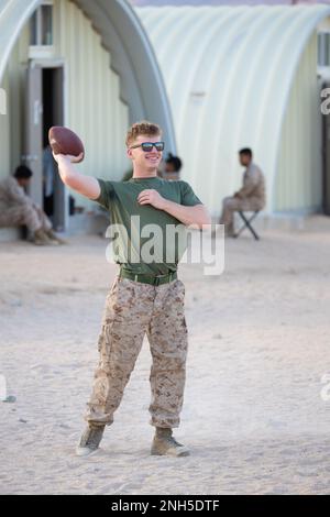 U.S. Marine Corps Cpl. John Grose, an automotive maintenance technician assigned to Bravo Company, Marine Wing Support Squadron 473, 4th Marine Aircraft Wing, from Fort Worth, Texas, throws a football at Camp Wilson, Marine Corps Air-Ground Combat Center, Twentynine Palms, Calif., during Integrated Training Exercise (ITX) 4-22, July 17, 2022. Reserve Marines and Sailors have come together from across the nation to form an integrated Marine Air-Ground Task Force to take part in a live-fire, combined arms exercise that will better prepare Marine Forces Reserve in its mission to augment and reinf Stock Photo