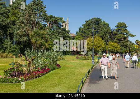 BOURNEMOUTH, UK - July 08, 2022. Elderly couple walking in a park holding hands in Bournemouth Lower Gardens, Dorset, UK. Old people mobility and reti Stock Photo