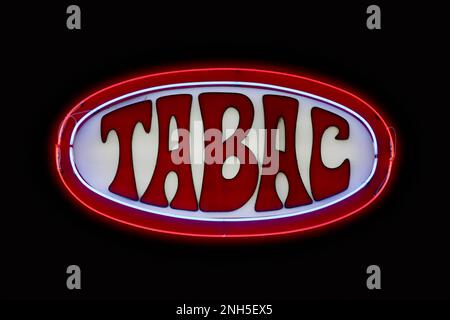 A red neon outside a tabacco retailer saying in French 'Tabac'. Stock Photo