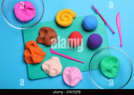 Flat lay composition with colorful plasticine on light blue background Stock Photo