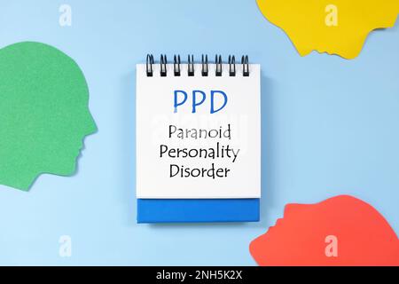 Paranoid personality disorder or PPD diagnosis written on notepad in blue background. Flat lay composition. Stock Photo