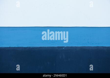 A wall painted in white, cyan and blue that can be used as wallpaper or as background for a graphic art designer. Stock Photo