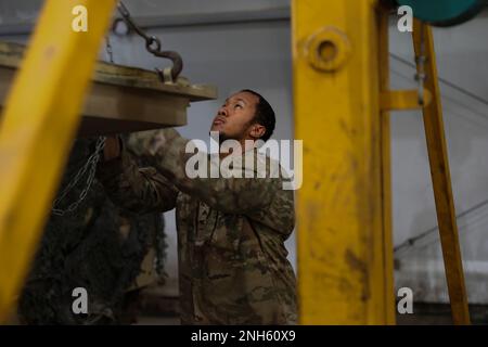 U.S. Army Sgt. Adonis Glover, shop foreman for Apache Troop, 4th Squadron, 10th Cavalry Regiment, 3rd Armored Brigade Combat Team, 4th Infantry Division, uses a chain to lower the grill of an M2A3 Bradley Fighting Vehicle during annual services at Trzebień, Poland, July 18, 2022. The 3/4 ABCT is among other units assigned to the 1st Infantry Division, proudly working alongside NATO allies and regional security partners to provide combat-credible forces to V Corps, America's forward-deployed corps in Europe. Stock Photo