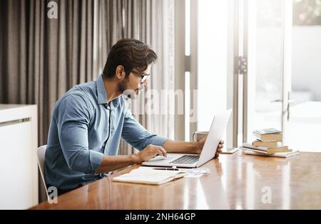 Working from home. a handsome young businessman working on his laptop in the office at home. Stock Photo