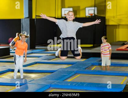 Tween girl having fun jumping in indoor trampoline arena Stock Photo ...