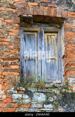 Old weathered shutters on a brick wall Stock Photo