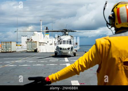 KOROR, Palau (July 19, 2022) — Aviation Boatswain’s Mate 3rd Class Nelson Benetmorales signals a SH-60K helicopter attached to Japan Maritime Self-Defense Force ship JS Kirisame (DD 104) aboard Military Sealift Command hospital ship USNS Mercy (T-AH 19) as part of a multilateral search and rescue exercise coordinated with the U.S. Navy, Republic of Palau, U.S. Coast Guard, Japan Maritime Self-Defense Force and Royal Navy in support of Pacific Partnership 2022. Now in its 17th year, Pacific Partnership is the largest annual multinational humanitarian assistance and disaster relief preparedness Stock Photo