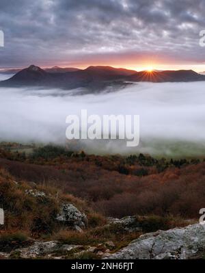 Dramatic autumn sunrise in mountain with red sky and clouds Stock Photo