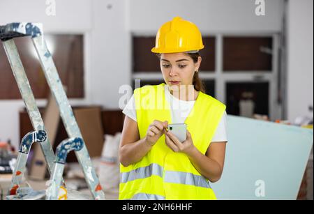 Young woman engineer using smartphone in construction site Stock Photo
