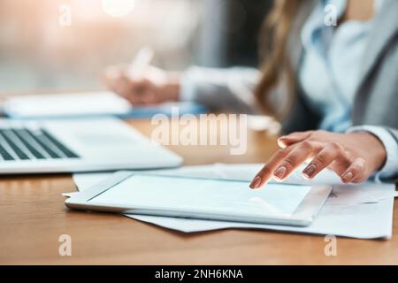 Shes one smart worker. Closeup shot of an unrecognizable businesswoman using a digital tablet in an office. Stock Photo