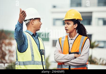 Supervisor, engineering and angry with people on construction site for project management, building and mistake. Designer, stress and architecture Stock Photo