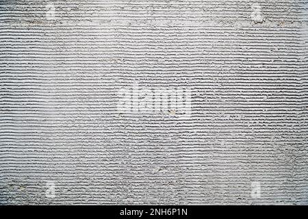 Gray decorative plaster on the wall with pressed horizontal stripes. Plaster background Stock Photo
