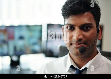 Portrait of smiling security manager standing in surveillance room Stock Photo