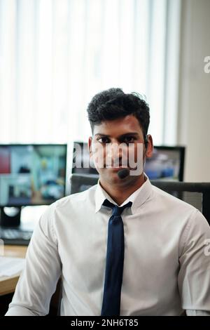 Portrait of smiling head of security department working in surveillance room Stock Photo