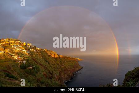 Landscape with rainbow over Canico at sunset time in Madeira Stock Photo